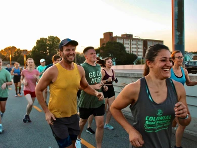 Runners share laughter and enjoyment during an evening city bridge run