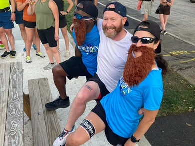 Race participants wearing fake beards and smiling at the Narragansett Brewery run